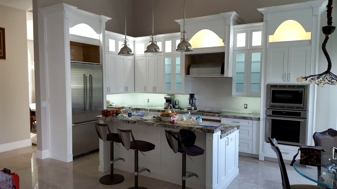 White shaker kitchen with granite island and pendant lighting