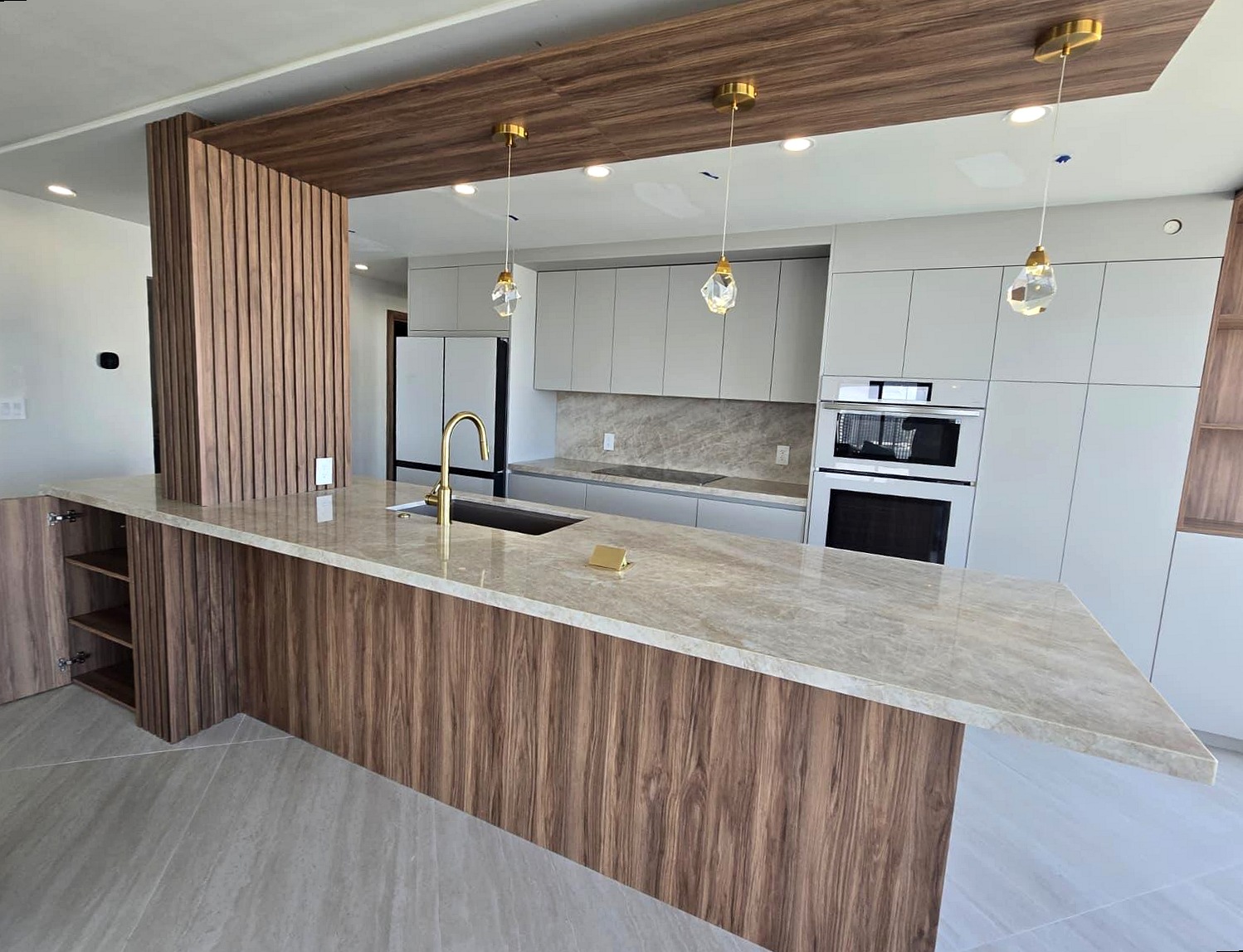 Custom walnut and quartz kitchen remodel with gold pendant lighting, South Florida